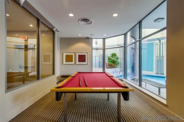 a living room with a table tennis pool table and windows