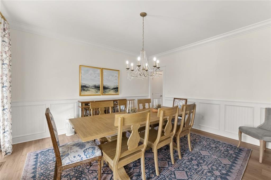 6998 Britt Gailey Road Clermont, GA 30527 - Photo 11 of 92 a view of a dining room with furniture a chandelier and wooden floor
