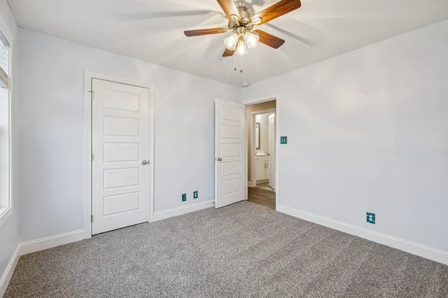 an empty room with closet and a chandelier fan