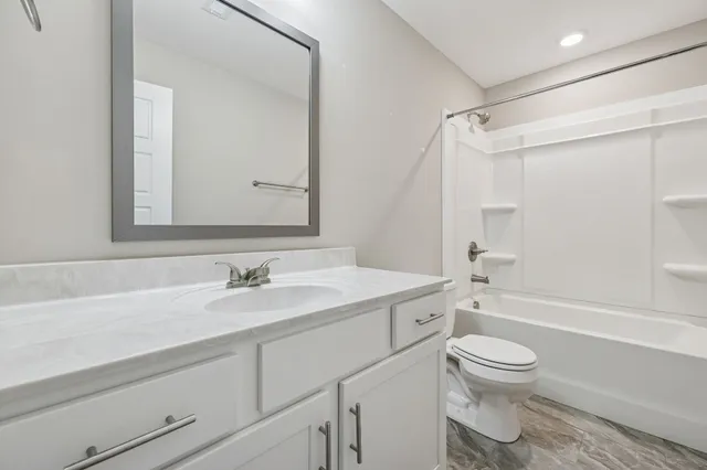 a bathroom with a sink toilet vanity and shower