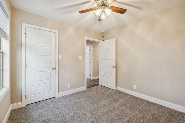 an empty room with closet and a chandelier fan