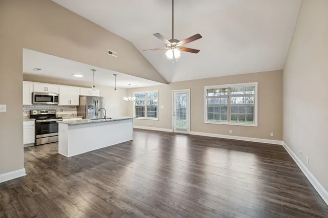 a view of kitchen with refrigerator stove and wooden floor