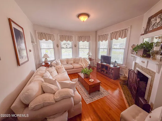 a living room with furniture fireplace and a large window