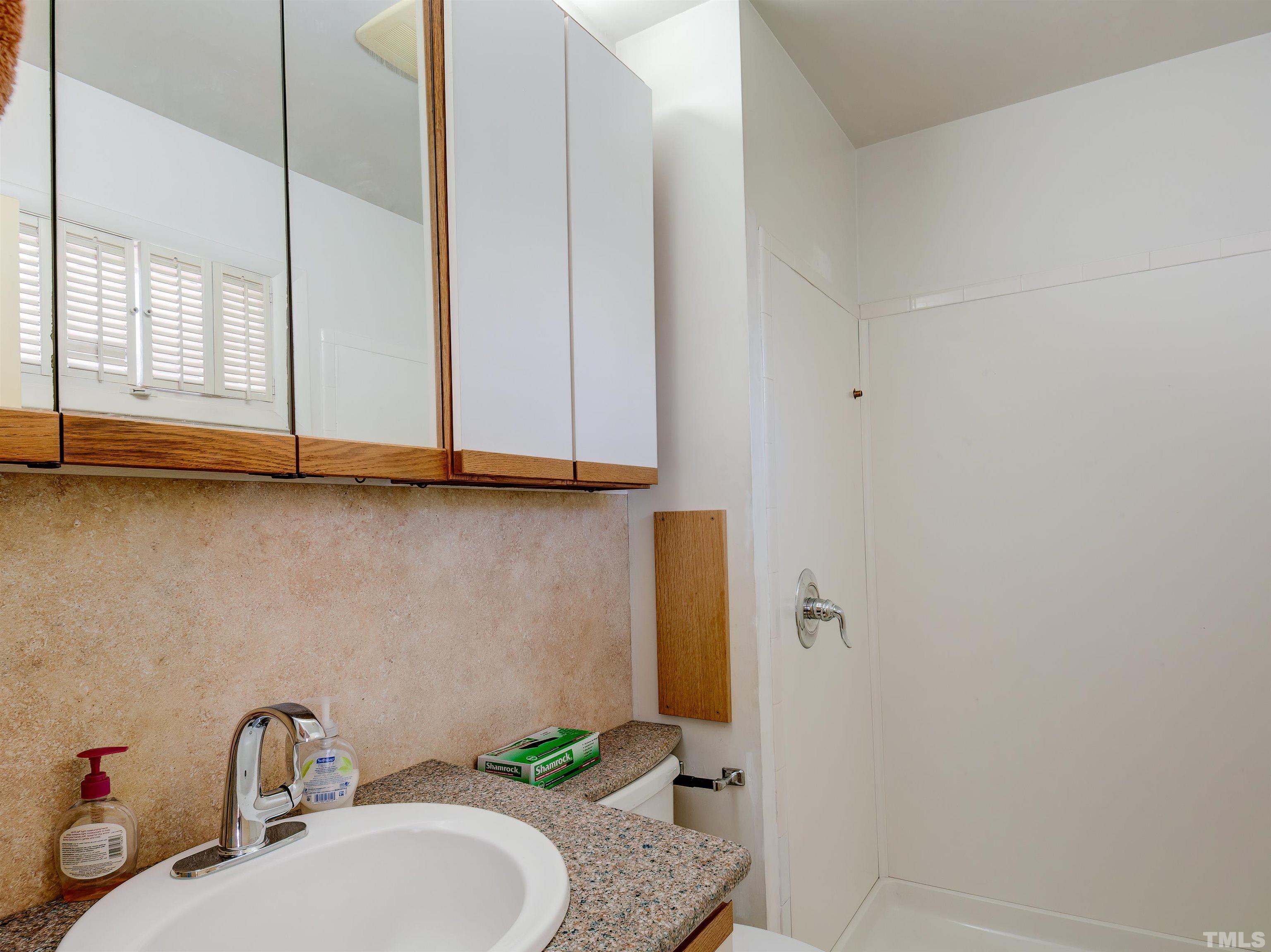 4821 Latimer Road Raleigh, NC 27609 - Photo 19 of 21 a bathroom with a granite countertop sink and a mirror