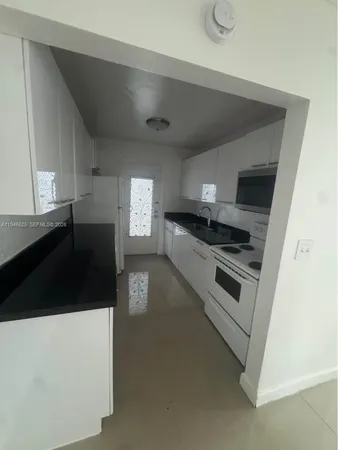 a kitchen with granite countertop a stove and a refrigerator