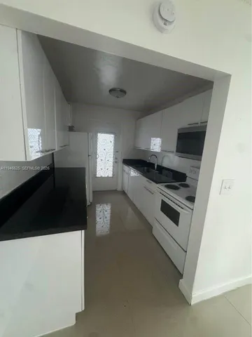 a kitchen with granite countertop a stove and a refrigerator