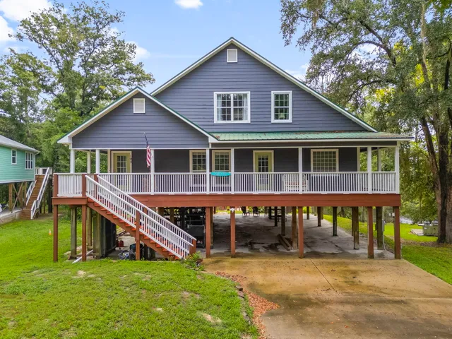 a view of a house with a yard balcony and sitting area
