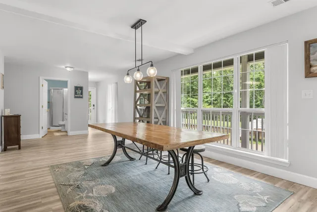 a kitchen with stainless steel appliances kitchen island granite countertop a table chairs and a refrigerator