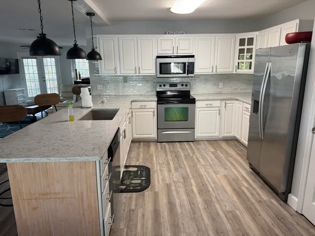 a kitchen with stainless steel appliances granite countertop a sink a stove and refrigerator