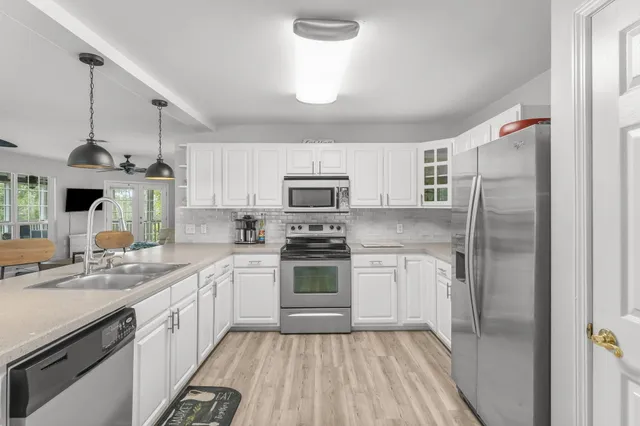 a kitchen with stainless steel appliances granite countertop a stove and white cabinets