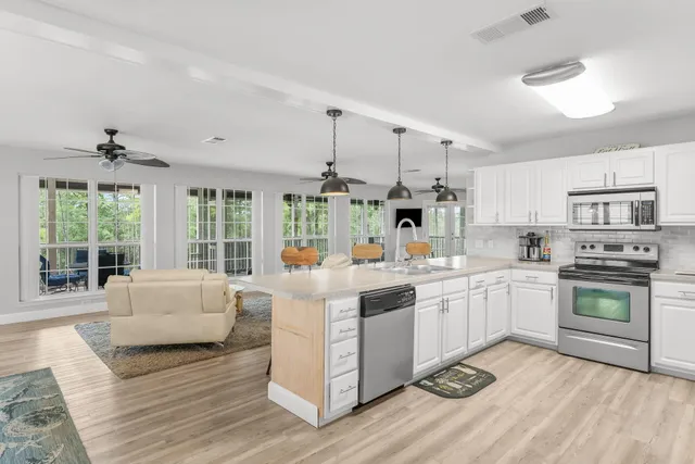 a living room with furniture a dining table and chairs with wooden floor