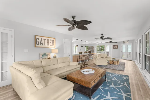a living room with furniture a flat screen tv and a large window