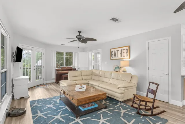 a living room with furniture a flat screen tv and a large window