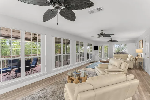 a living room with furniture kitchen view and a chandelier