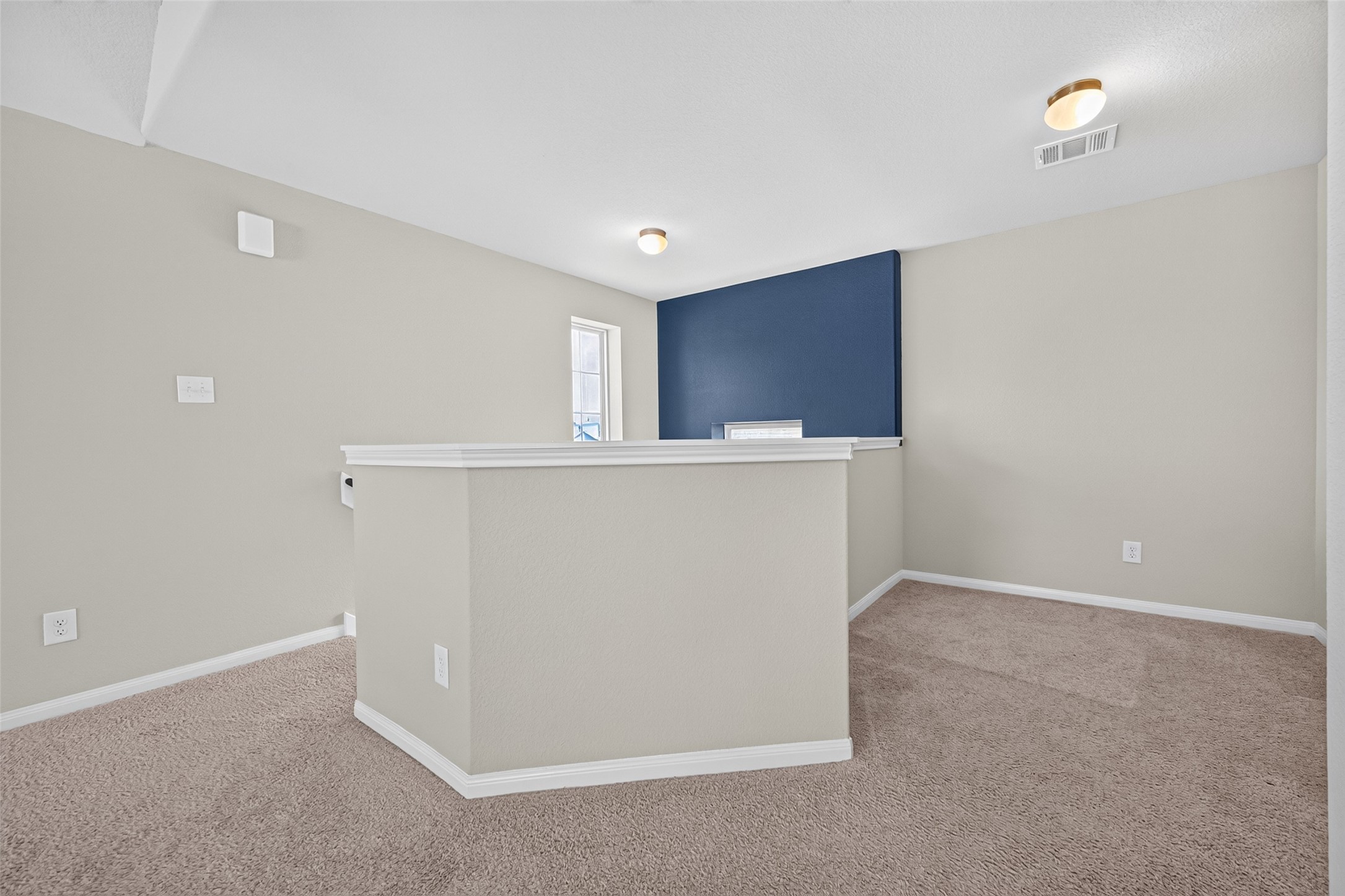 2526 Sturgeon Way Conroe, TX 77384 - Photo 35 of 49 This photo shows a carpeted loft space with neutral walls and a blue accent wall. It features a small window and recessed lighting, creating a cozy and versatile area that can serve multiple purposes.