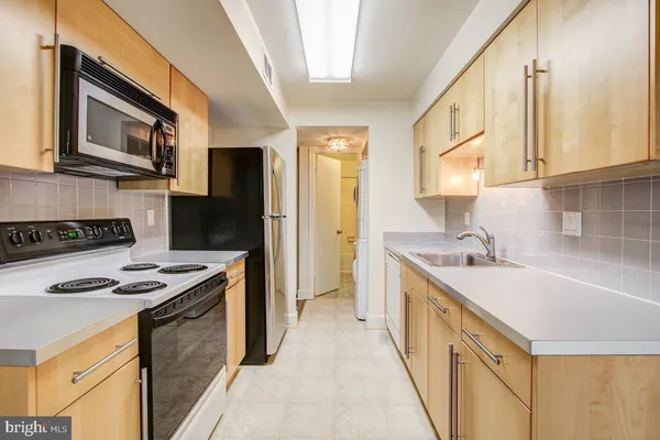 a kitchen with stainless steel appliances granite countertop a sink and a stove