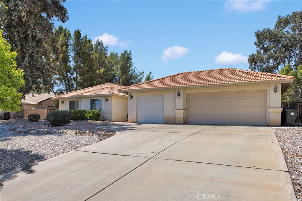 20403 Ochoa Road Apple Valley, CA 92307 - Photo 4 of 48 a front view of a house with a yard and garage