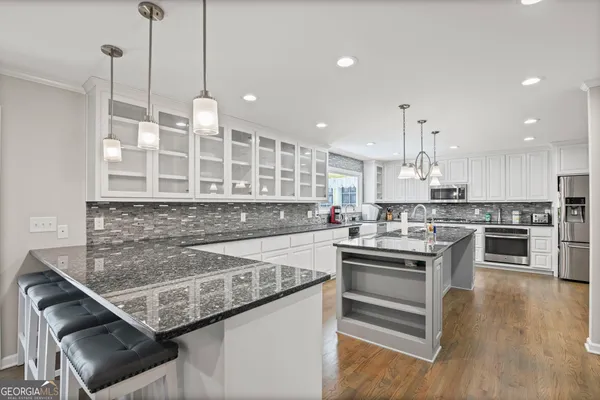 a kitchen with kitchen island granite countertop a sink stove and cabinets