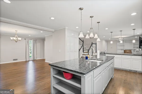 a kitchen with stainless steel appliances granite countertop a sink a refrigerator and a stove top oven