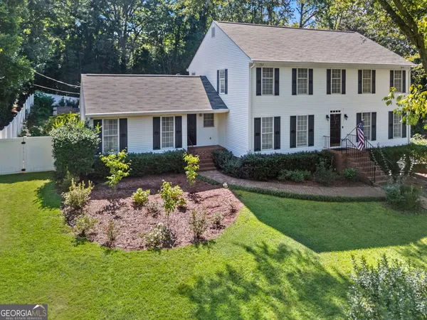 a aerial view of a house next to a big yard and potted plants