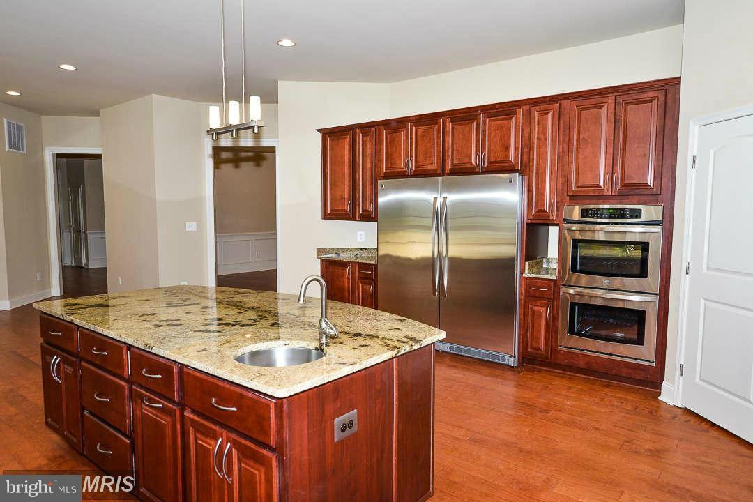 8536 Old Keene Mill Road Springfield, VA 22152 - Photo 2 of 30 a kitchen with kitchen island granite countertop cabinets and stainless steel appliances