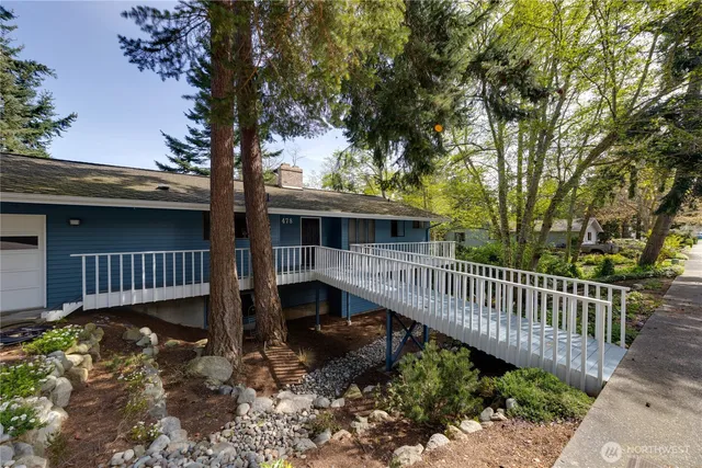 a view of a deck with a wooden fence and a large tree