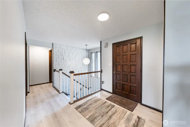 a view of a hallway with wooden floor and stairs