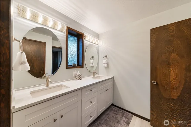 a bathroom with a double vanity sink and mirror