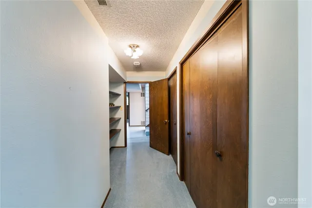 a view of a hallway with wooden shelves