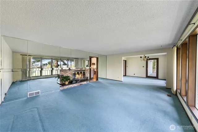 a view of an empty room with a fireplace and a window