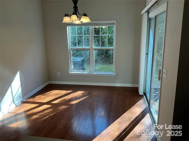 a view of a room with wooden floor and a window