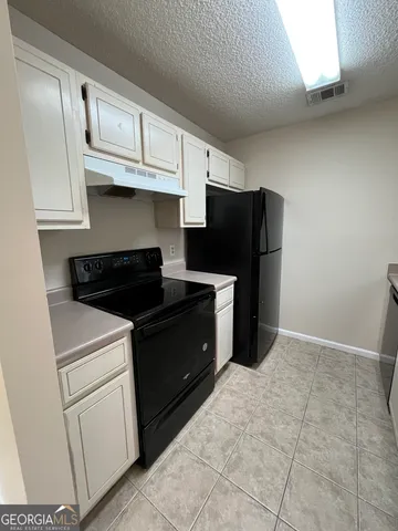 a kitchen with a refrigerator and cabinets