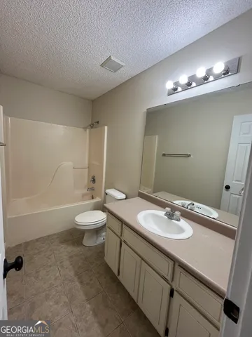 a bathroom with a double vanity sink toilet and a mirror