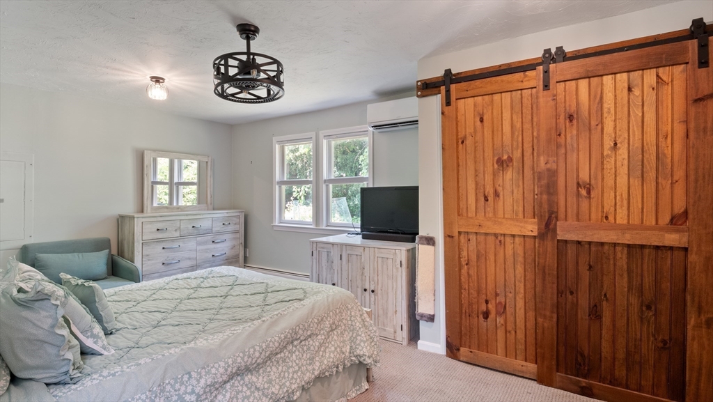 16 Sandy Cove Road Lunenburg, MA 01462 - Photo 15 of 38 a bedroom with a large bed and a flat tv screen on dresser