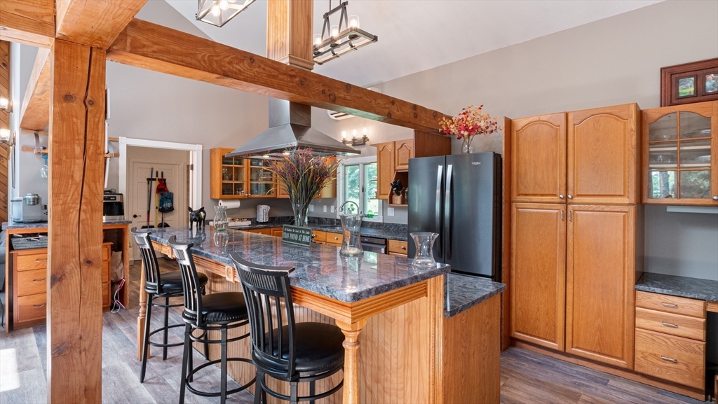 16 Sandy Cove Road Lunenburg, MA 01462 - Photo 20 of 38 a kitchen with stainless steel appliances granite countertop a refrigerator a stove and a dining table with wooden floor