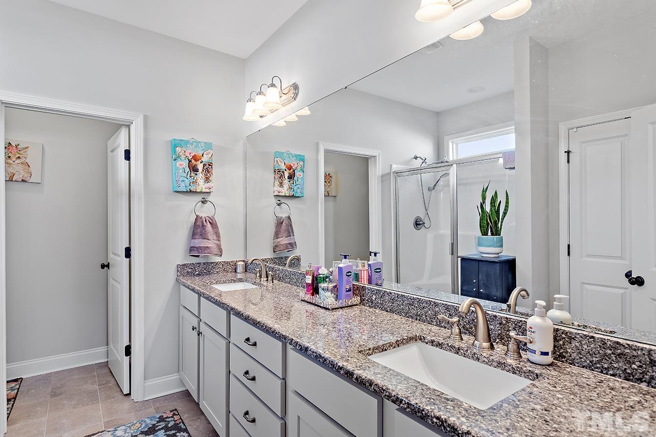 196 Fairview Street Clayton, NC 27520 - Photo 13 of 21 a bathroom with double vanity sinks a vanity a lamp and a mirror