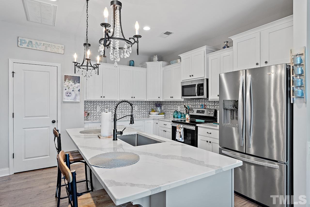 196 Fairview Street Clayton, NC 27520 - Photo 8 of 21 a kitchen with stainless steel appliances granite countertop a dining table and chairs