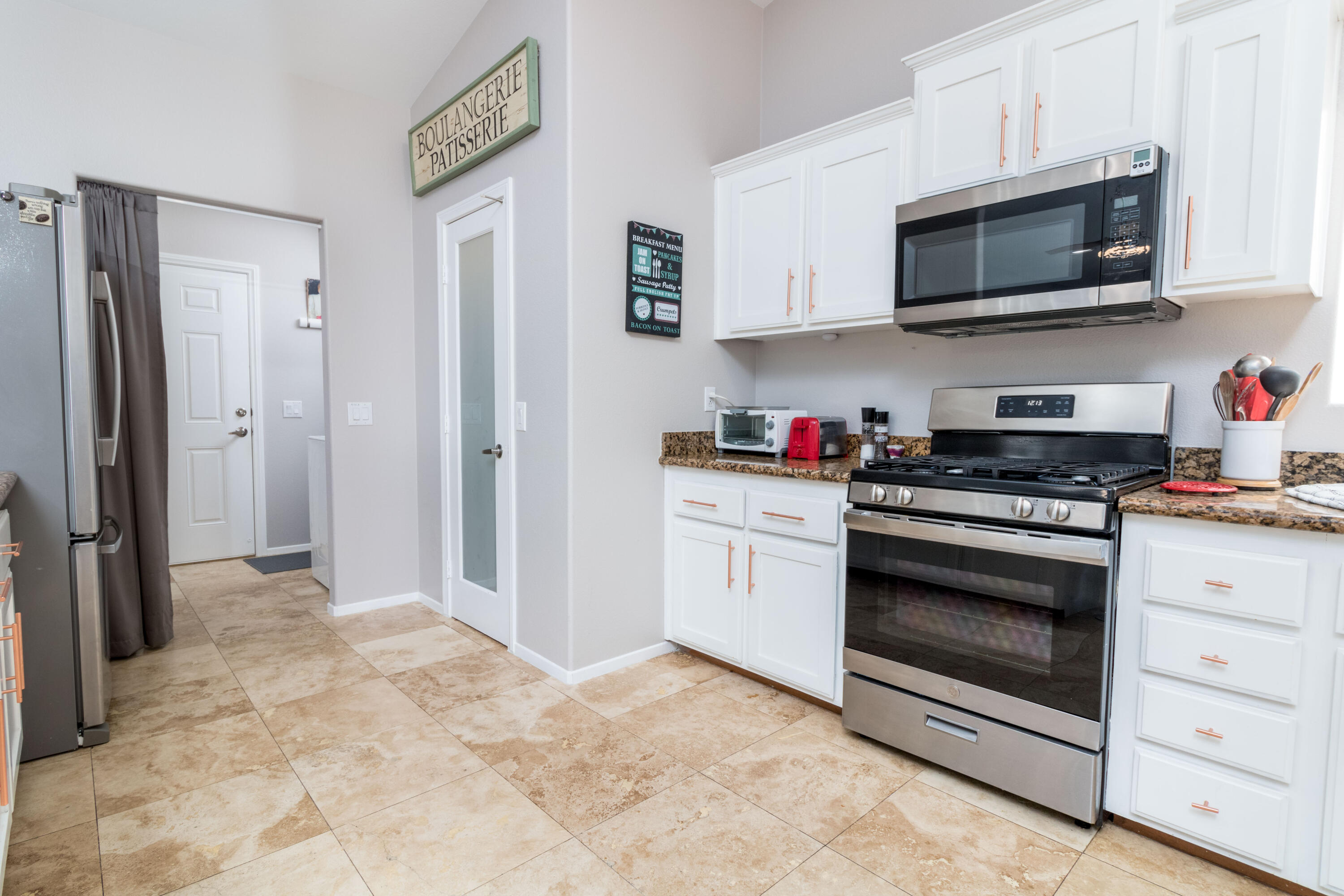 12753 Mountain View Road Desert Hot Springs, CA 92240 - Photo 19 of 45 a kitchen with stainless steel appliances granite countertop a stove microwave and a sink