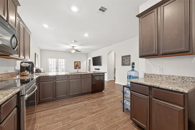 a kitchen with granite countertop a sink stove and refrigerator