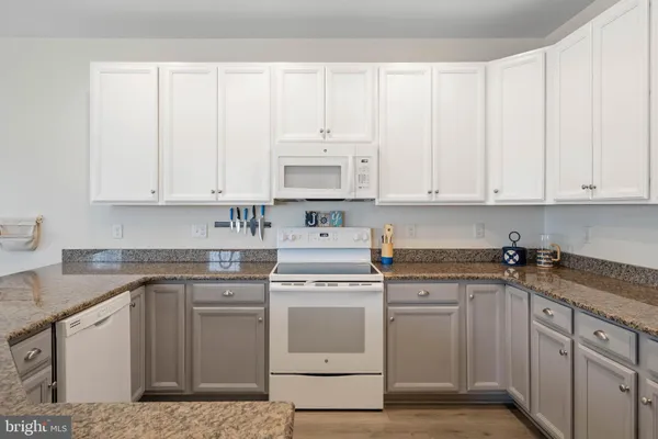 a kitchen with white cabinets and white appliances