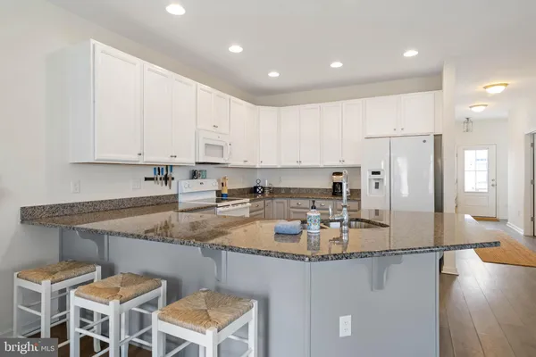 a kitchen with stainless steel appliances granite countertop a sink refrigerator and cabinets