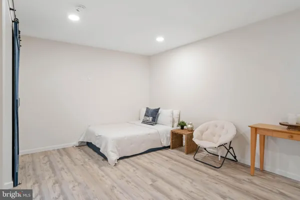a spacious bedroom with a bed and wooden floor