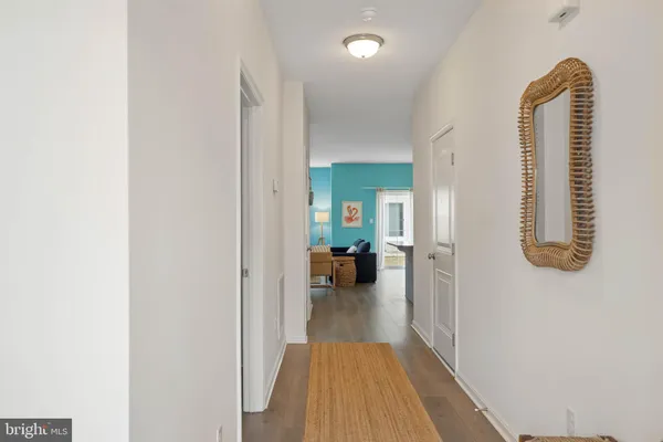 a view of a hallway with wooden floor and furniture