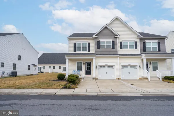 a view of a house with backyard and parking