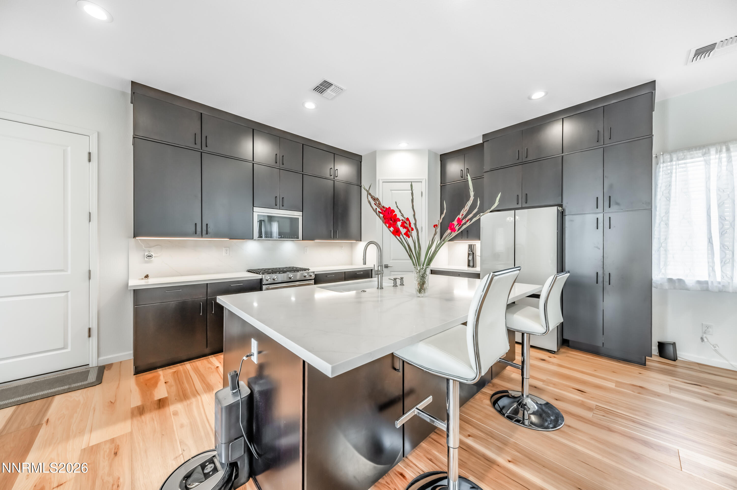 2402 Iron Square Drive Reno, NV 89521 - Photo 9 of 30 a kitchen with stainless steel appliances granite countertop a sink a stove a refrigerator with a dining table and chairs