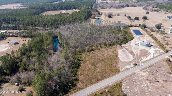 a view of a dry yard with wooden fence