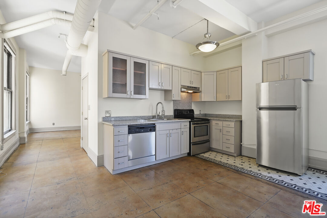 108 West 2nd Street, Unit 708 Los Angeles, CA 90012 - Photo 12 of 40 a kitchen with refrigerator cabinets and a sink