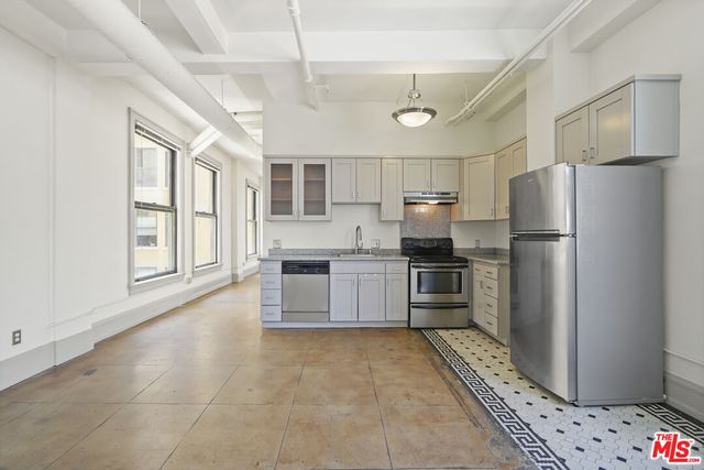 a kitchen with granite countertop a stove sink and cabinets
