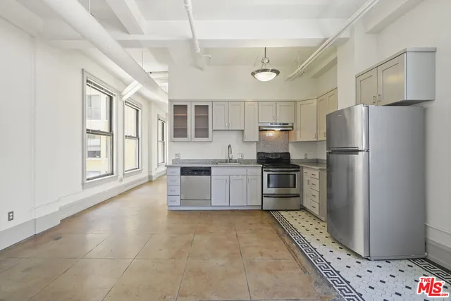 a kitchen with granite countertop a stove sink and cabinets