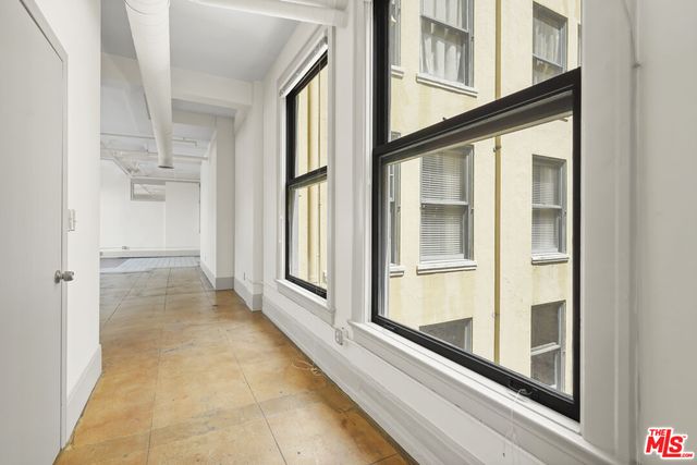 an empty room with an entryway and chandelier fan